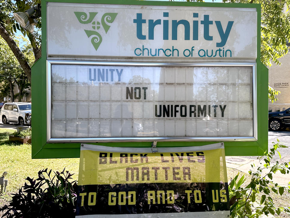 Trinity Church of Austin marquee sign that displays the message "Unity Not Uniformity". Beneath the sign a black and yellow banner reads "Black Lives Matter To God And To Us".