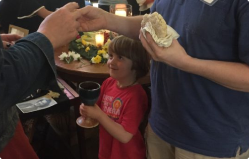 Child and Adults Taking Communion at Trinity Church of Austin